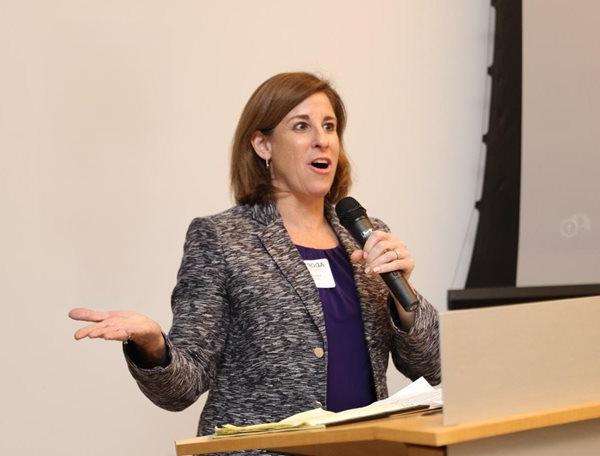 woman speaking into microphone at podium